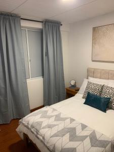Un dormitorio con una cama grande y una ventana en Confortable Apartaestudio, en Bogotá