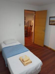1 dormitorio con 2 camas y puerta con mesa en Departamentos Yexalen PA en El Calafate