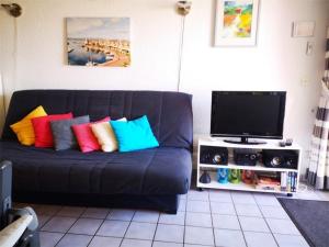 un sofá negro con almohadas coloridas en la sala de estar. en Appartement Port Barcarès, 2 pièces, 4 personnes - FR-1-195-7, en Le Barcarès