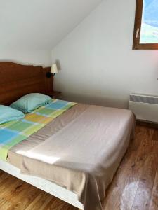 um quarto com uma cama num quarto com uma janela em VVF Résidence Albiez-Montrond Maurienne em Albiez-Montrond