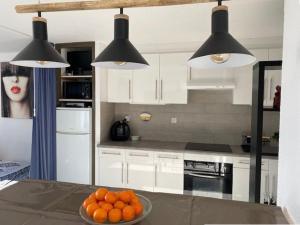 a kitchen with a bowl of oranges on a table at Studio Cabine à Le Barcarès, 4 couchages, terrasse, parking, piscine et activités sportives - FR-1-195-23 in Le Barcarès