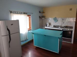 cocina con encimera azul y nevera en Departamentos Yexalen PA en El Calafate
