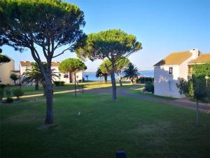 a yard with trees and a house and the ocean at Studio Cabine à Le Barcarès, 4 couchages, terrasse, parking, piscine et activités sportives - FR-1-195-23 in Le Barcarès