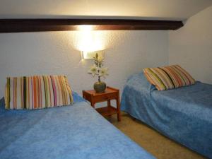 een hotelkamer met 2 bedden en een tafel met een lamp bij Maison Saint-Cyprien, 2 pièces, 6 personnes - FR-1-225D-177 in Saint Cyprien Plage