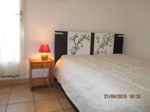 een slaapkamer met een bed en een tafel met een lamp bij Maison Saint-Cyprien, 3 pièces, 6 personnes - FR-1-225D-216 in Saint Cyprien Plage