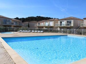 a large blue swimming pool in front of some apartments at Appartement Gruissan, 2 pièces, 4 personnes - FR-1-229-372 in Gruissan
