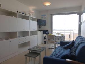 uma sala de estar com armários brancos e um sofá azul em Appartement Saint-Gilles-Croix-de-Vie, 2 pièces, 4 personnes - FR-1-224-40 em Saint-Gilles-Croix-de-Vie