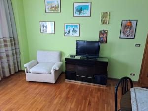 uma sala de estar com uma cadeira e uma televisão de ecrã plano em CONCO HOUSE em Calalzo