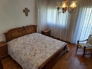 um quarto com uma cama grande e uma cruz na parede em CONCO HOUSE em Calalzo