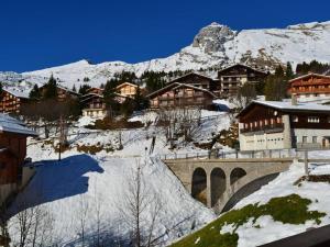 a snow covered mountain with a bridge and buildings at Appartement Le Grand-Bornand, 2 pièces, 6 personnes - FR-1-241-16 in Le Grand-Bornand