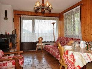 - un salon avec un canapé rouge et une table dans l'établissement Appartement Le Grand-Bornand, 3 pièces, 6 personnes - FR-1-241-42, au Grand-Bornand