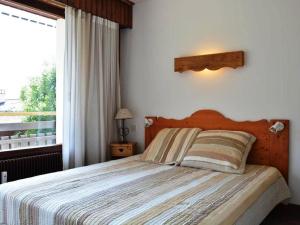 ein Schlafzimmer mit einem großen Bett und einem Fenster in der Unterkunft Appartement Le Grand-Bornand, 3 pièces, 6 personnes - FR-1-241-47 in Le Grand-Bornand