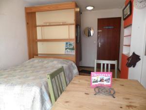 Un dormitorio con una cama y una mesa con un libro en Appartement Gruissan, 2 pièces, 4 personnes - FR-1-229-292, en Gruissan