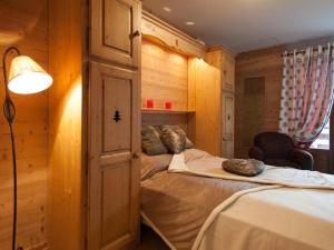 um quarto com uma cama num quarto com paredes de madeira em Appartement Le Grand-Bornand, 3 pièces, 6 personnes - FR-1-241-35 em Le Grand-Bornand