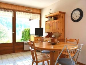 a dining room with a table and a clock on the wall at Appartement Le Grand-Bornand, 2 pièces, 4 personnes - FR-1-241-91 in Le Grand-Bornand