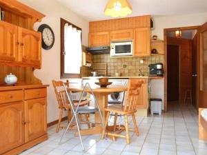 a kitchen with wooden cabinets and a table and chairs at Appartement Le Grand-Bornand, 2 pièces, 4 personnes - FR-1-241-91 in Le Grand-Bornand