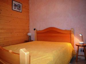 a bedroom with a wooden bed with a yellow blanket at Appartement Le Grand-Bornand, 2 pièces, 4 personnes - FR-1-241-91 in Le Grand-Bornand