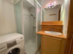 a bathroom with a shower and a sink and a washing machine at Appartement Le Grand-Bornand, 2 pièces, 6 personnes - FR-1-241-131 in Le Grand-Bornand