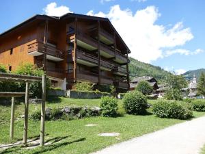 a large building with a grassy yard in front of it at Appartement Le Grand-Bornand, 2 pièces, 6 personnes - FR-1-241-131 in Le Grand-Bornand