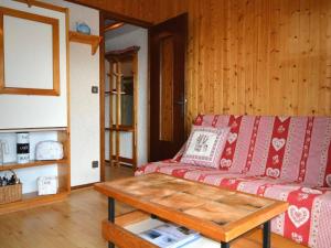 a living room with a red couch and a coffee table at Appartement Le Grand-Bornand, 1 pièce, 4 personnes - FR-1-241-66 in Le Grand-Bornand