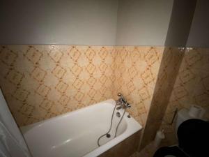 uma banheira na casa de banho com uma parede em azulejo em Appartement Le Grand-Bornand, 1 pièce, 4 personnes - FR-1-241-75 em Le Grand-Bornand