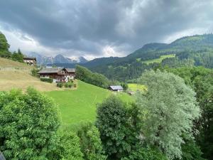 a green hillside with houses and trees on it at Appartement Le Grand-Bornand, 1 pièce, 4 personnes - FR-1-241-75 in Le Grand-Bornand