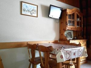 uma mesa de jantar com 2 cadeiras e uma televisão em Appartement Le Grand-Bornand, 2 pièces, 5 personnes - FR-1-241-85 em Le Grand-Bornand