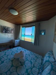 a bedroom with a bed with a view of the ocean at Pousada Casa do Telhado Verde in Cabo Frio