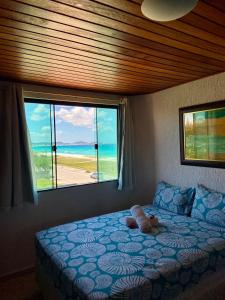 Un dormitorio con una cama con vista al mar. en Pousada Casa do Telhado Verde, en Cabo Frío