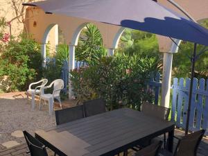 ル・バルカレスにあるVilla Port Barcarès, 2 pièces, 4 personnes - FR-1-81-260の青い柵と傘付きのテーブルと椅子