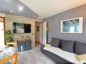 een woonkamer met een bank en een flatscreen-tv bij Appartement Le Grand-Bornand, 2 pièces, 4 personnes - FR-1-241-105 in Le Grand-Bornand