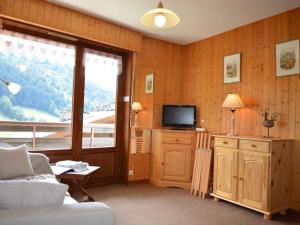 a living room with a couch and a tv and a window at Appartement Le Grand-Bornand, 1 pièce, 4 personnes - FR-1-241-112 in Le Grand-Bornand