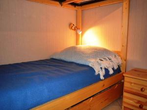 1 dormitorio con 1 cama con manta azul y lámpara en Appartement Le Grand-Bornand, 2 pièces, 6 personnes - FR-1-241-111, en Le Grand-Bornand