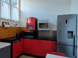 コトレにあるAppartement Cauterets, 3 pièces, 6 personnes - FR-1-234-109のキッチン(赤いキャビネット、ステンレス製の冷蔵庫付)