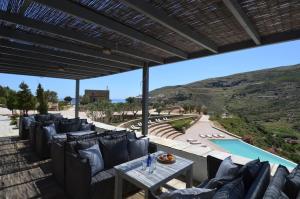 a patio with chairs and a table and a pool at Aegea Blue Cycladic Resort in Zorgos 