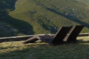 a bench sitting on top of a grassy hill at Aegea Blue Cycladic Resort in Zorgos 