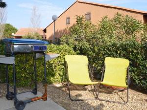 zwei gelbe Stühle und ein Grill im Hof in der Unterkunft Maison Narbonne, 3 pièces, 6 personnes - FR-1-229B-467 in Narbonne