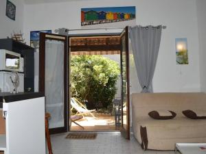 sala de estar con sofá y puerta corredera de cristal en Maison Saint-Cyprien, 2 pièces, 6 personnes - FR-1-225D-323, en Saint Cyprien Plage