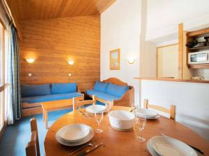 a dining room with a table and a couch at Appartement Valmorel, 3 pièces, 7 personnes - FR-1-291-708 in Valmorel