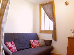 ein blaues Sofa im Wohnzimmer mit Fenster in der Unterkunft Studio divisible à Valmorel - Linge et Ménage Inclus - FR-1-291-702 in Valmorel