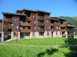 een groot appartementencomplex met een groen gazon ervoor bij Appartement Valmorel, 1 pièce, 4 personnes - FR-1-291-702 in Valmorel