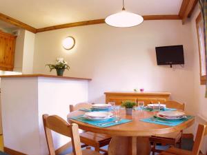 uma sala de jantar com uma mesa de madeira e cadeiras em Appartement Valmorel, 3 pièces, 7 personnes - FR-1-291-726 em Valmorel
