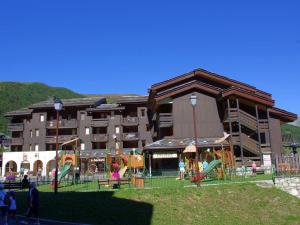 a large building with a playground in front of it at Appartement Valmorel, 1 pièce, 4 personnes - FR-1-291-748 in Valmorel