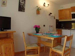 a kitchen with a wooden table with chairs and a television at Studio Valmorel, 1 pièce, 2 personnes - FR-1-291-737 in Valmorel