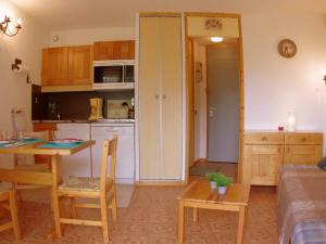 a kitchen and a living room with a table and chairs at Studio Valmorel, 1 pièce, 2 personnes - FR-1-291-737 in Valmorel