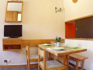 a dining room table with two chairs and a television at Appartement Valmorel, 1 pièce, 4 personnes - FR-1-291-748 in Valmorel