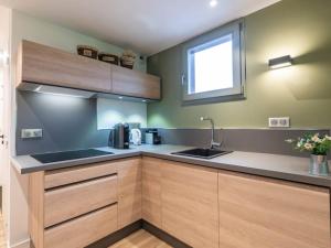 a kitchen with wooden cabinets and a sink and a window at Appartement Valmorel, 3 pièces, 7 personnes - FR-1-291-743 in Valmorel