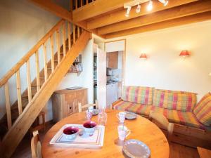 a dining room with a table and a couch at Appartement Valmorel, 2 pièces, 5 personnes - FR-1-291-761 in Valmorel