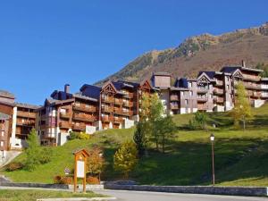 um grupo de edifícios de apartamentos numa colina com uma montanha em Appartement Valmorel, 2 pièces, 5 personnes - FR-1-291-761 em Valmorel