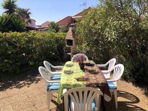 樂巴凱爾斯的住宿－Villa Port Barcarès, 3 pièces, 6 personnes - FR-1-81-372，一张桌子、白色的椅子和一张鲜花桌子